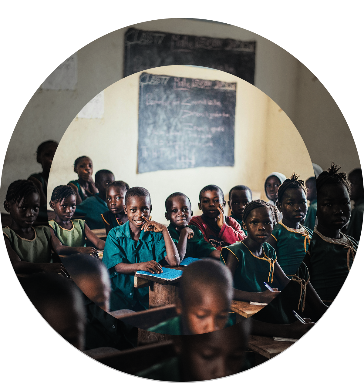 Children sitting a class, looking at the camera and smilling