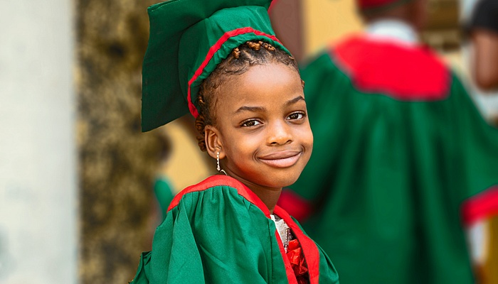 Child in graduation down smiling